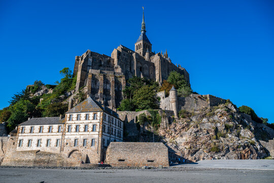 Mont St. Michel stands tall above the bay in France, showcasing its rich history and architecture under a clear sky