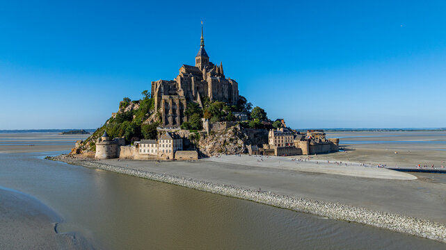 Aerial view of Mont St. Michel showcasing its architecture and the surrounding landscape during clear weather in France
