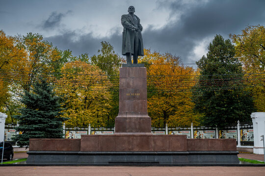 Lenin statue stands in a park surrounded by autumn trees in Gomel, Belarus, under a cloudy sky