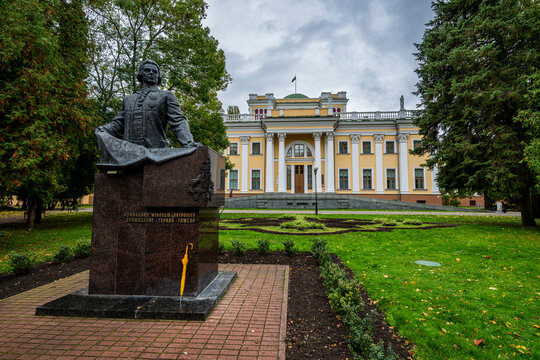 Exploring the Rumyantsev-Paskevich Residence with a statue in front, in Gomel, Belarus, showcasing the historic architecture and greenery