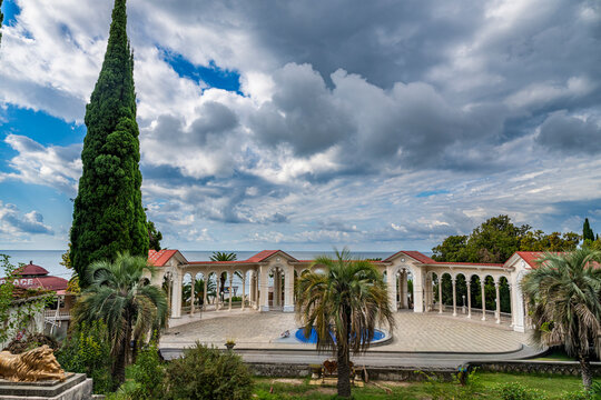 Visitors explore Gagra Colonnade by the sea in Gagra, Abkhazia under cloudy skies