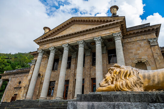 Historic building showcasing architectural design in Gagra, Abkhazia, with a lion statue in front