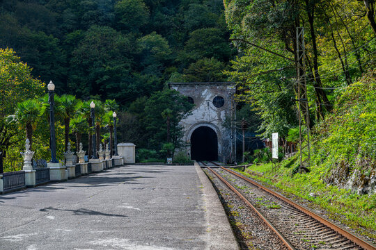 Old train tunnel stands at the end of the railway in New Athon surrounded by green trees and a quiet path