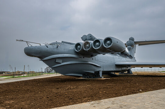 Large hovercraft on display in Dagestan, Russia near a park area with cloudy sky overhead