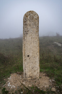 Lezgor Necropolis shrouded in fog with ancient stone in view, North Ossetia, Russia