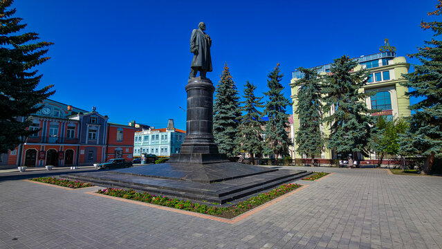 Lenin statue stands in center of Vladikavkaz surrounded by trees and buildings in North Ossetia, Russia