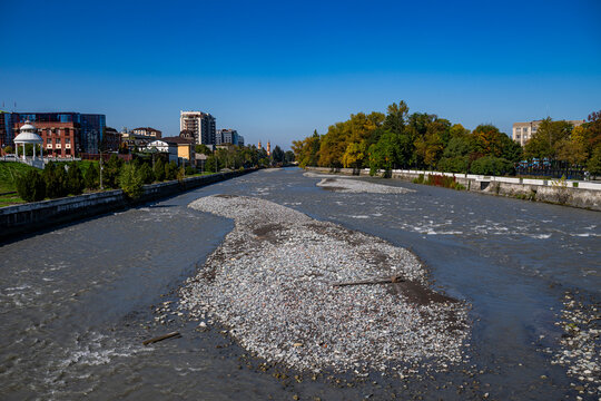 View of the Terek River with rocky banks and buildings in the background in Vladikavkaz, North Ossetia, Russia