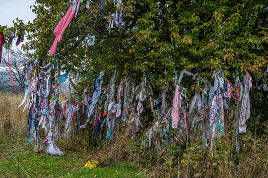 Colorful prayer flags hang from trees near St. George Church in the Republic of South Ossetia during a cloudy day in autumn