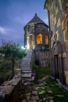 Tiri monastery stands on a hillside with a stone staircase leading to a lit entrance in the evening in South Ossetia