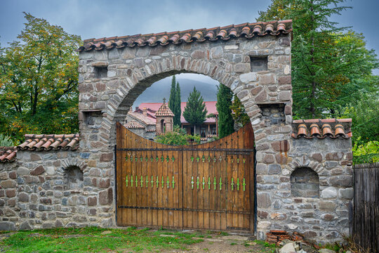 Orthodox Ikoti Monastery entrance showing stone architecture and wooden gates in Leningor region