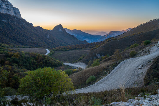 Remote mountain scenery shows winding roads and hills during sunset in Chechnya, Caucasus region in Russia