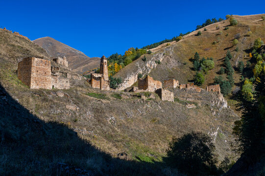 Abandoned mountain village situated in Caucasus region of Russia with old stone buildings under clear blue sky