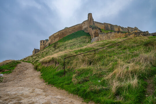 Naryn-Kala fortress stands on a hill overlooking the landscape of Dagestan, showcasing its historic architecture under a cloudy sky