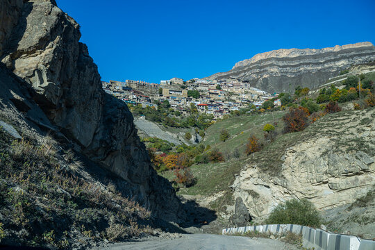 View of Tschoch village in Dagestan surrounded by rocky hills and clear blue sky during daylight hours