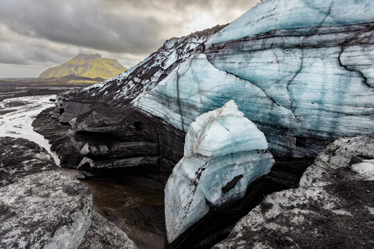 View of Katla glacier with blue ice and volcanic ash in Iceland surrounded by mountains