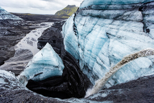 Close view of glacier surface showing volcanic sediment and meltwater channels in Icelandic ice near Vik