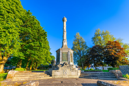 Wallace Birthplace Monument stands tall in Elderslie surrounded by trees under a clear blue sky in Scotland