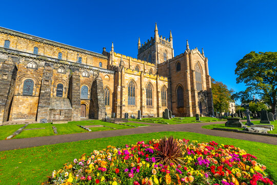 Exploring the architecture of Dunfermline Abbey with colorful flowers in the foreground in Dunfermline, Scotland