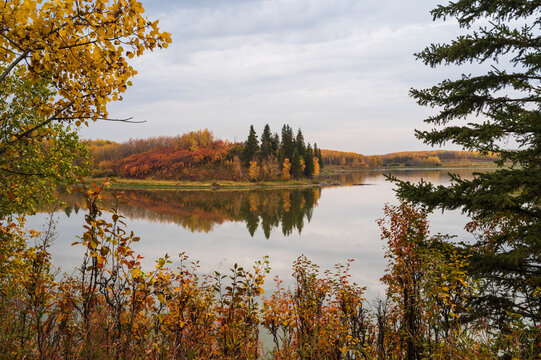 Vibrant autumn colors surround Astotin Lake in Elk Island National Park, Alberta, Canada showcasing nature's seasonal change