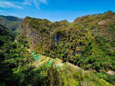 Elevated view of Semuc Champey Natural Monument shows lush landscape and clear waters in Guatemala during the daytime