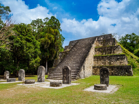 East pyramid of Group Q with stone stelae in Tikal, showcasing ancient Mayan architecture and history