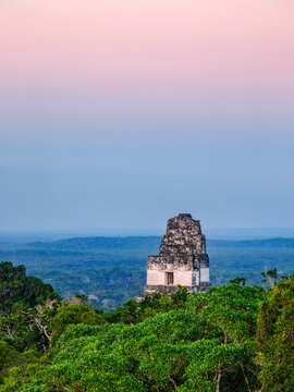 View of Temple I at dusk with trees and distant hills in Tikal, Peten Department, Guatemala