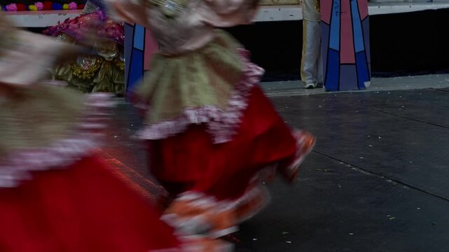 Cultural dancers twirl in their skirts as they perform at a trade fair presentation.