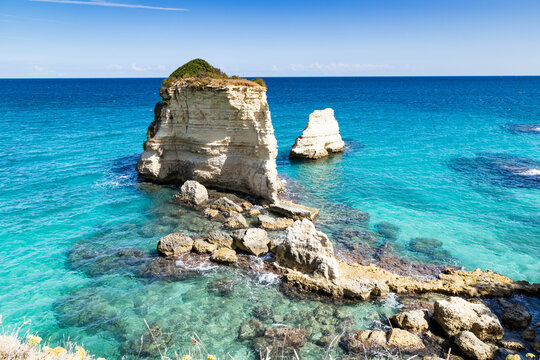 Explore the faraglioni di Sant Andrea in Salento Italy during a sunny day near the clear blue sea