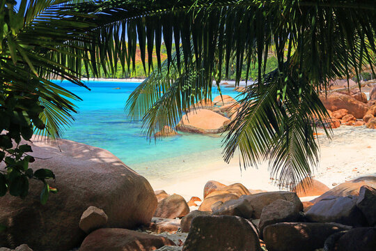 Clear waters and rocky shores invite visitors to explore the beauty of Anse Lazio beach in Seychelles during a sunny day