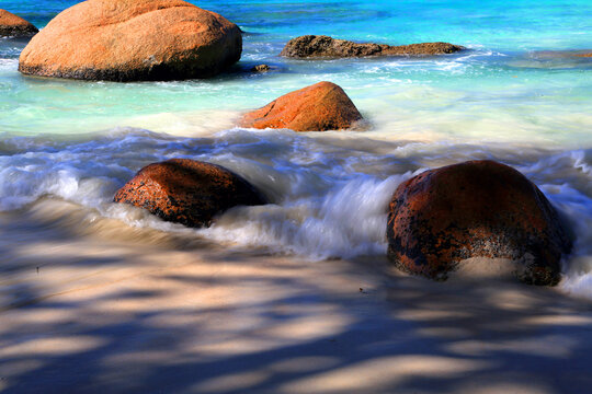 Enjoy warm waves and rocks at Anse Lazio beach in Seychelles during a sunny day in tropical paradise