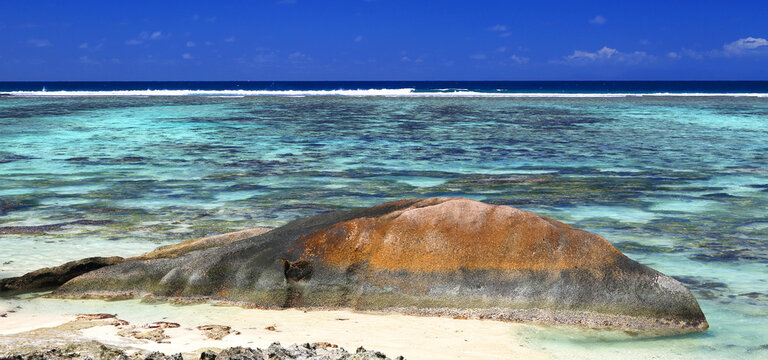 Visit to the beach with clear water and large rocks on the shore at Anse Source dArgent in Seychelles during sunny weather