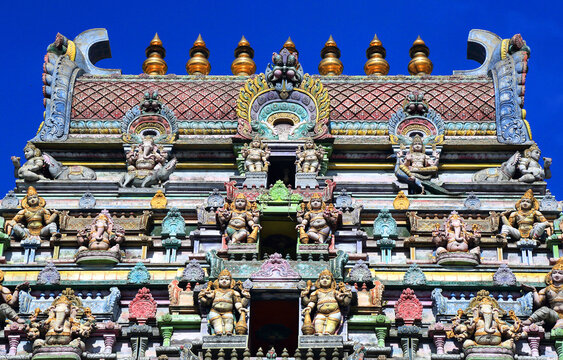 Visitors admire the detailed architecture of Arul Mihu Navasakthi Vinayagar Temple in Seychelles during a sunny day