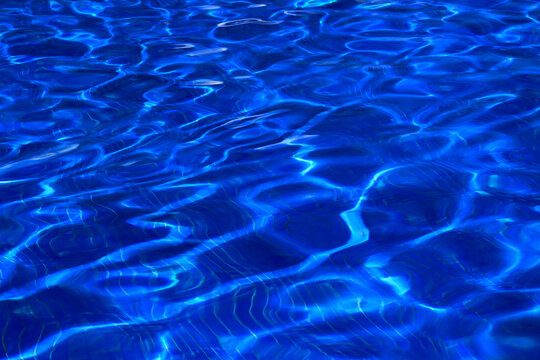 Clear blue water waves form patterns in the pool at a resort in Seychelles under the bright sun