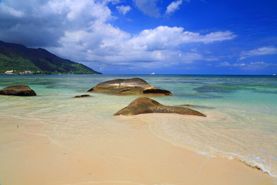 Explore Beau Vallon Beach in Mahe, Seychelles with clear water and unique rock formations during a sunny day