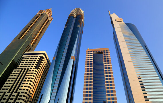 Modern architecture in central Dubai showcases a mix of design styles with skyscrapers towering against a clear blue sky in the UAE