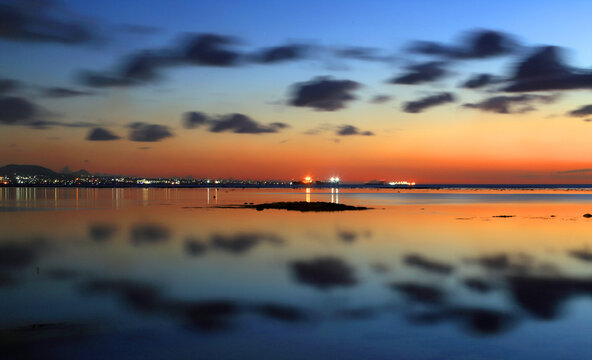 View of Port Louis at twilight with reflections on water and clouds above in Mauritius