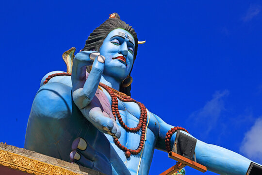 Large statue of Lord Shiva stands against blue sky in a Hindu temple in Mauritius