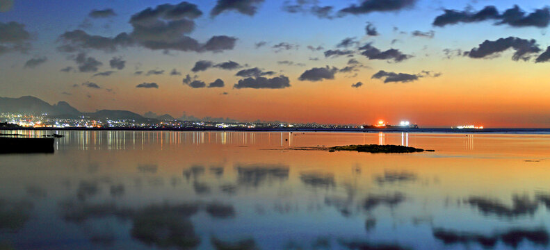 View of Port Louis at twilight with reflections in the water and city lights in the background