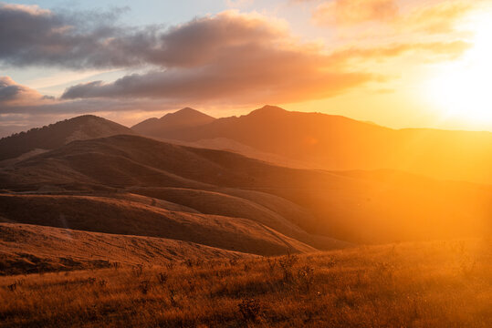 Golden sunset over rugged hills in Marlborough Sounds, South Island, New Zealand