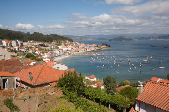 Rooftops and boats viewed from A Granxa near Sanxenxo in Galicia, Spain on a clear day in summer
