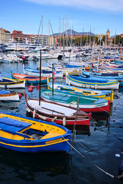 Colorful boats fill Nice Port near the water with yachts and buildings in the background in Cote dAzur, France