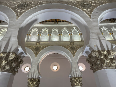 Exploring the intricate arches and decorations inside Santa Maria La Blanca synagogue in Toledo, Spain during daylight