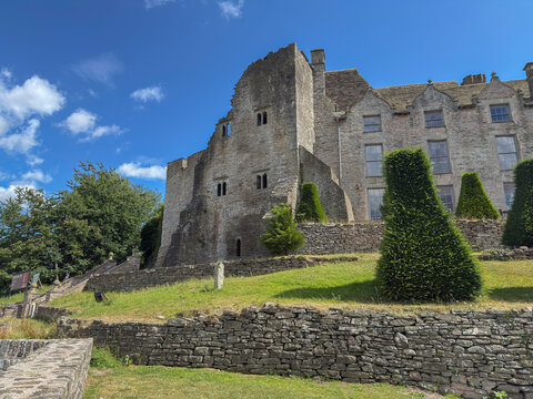 Explore the historic structure and grounds of a castle in Hay on Wye with clear blue skies above in Powys, Wales