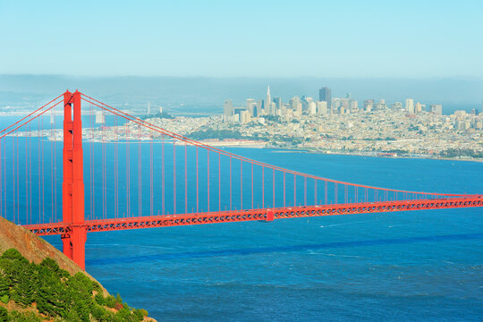 View of Golden Gate Bridge and financial district of San Francisco with clear blue sky and calm waters in the background
