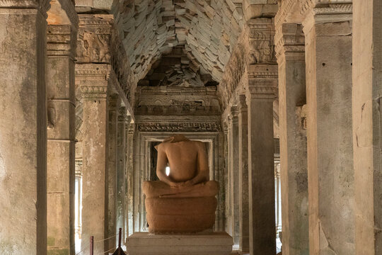 Exploring the ancient ruins of Ta Prohm Temple with a stone statue in Cambodia