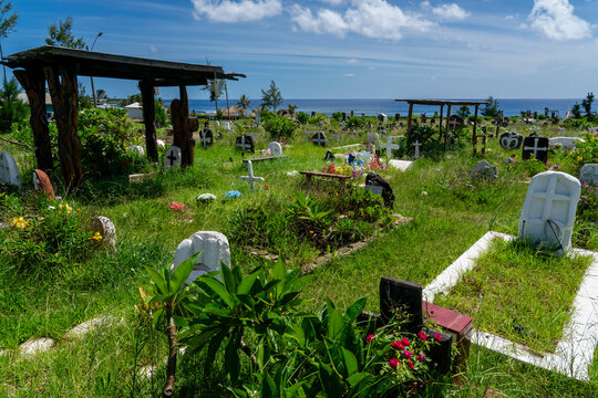 Exploring Hanga Roa cemetery with green landscapes and wooden structures near the coast in Rapa Nui, Chile