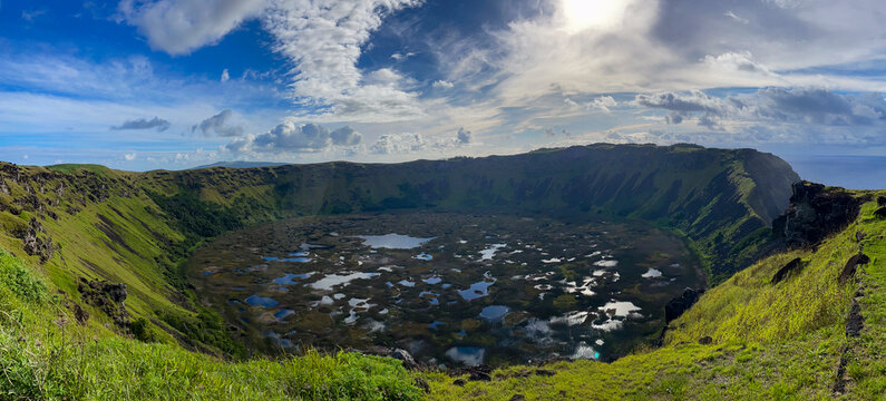 View of Rano Kau Volcano with pools and greenery under a bright sky at Easter Island during the day