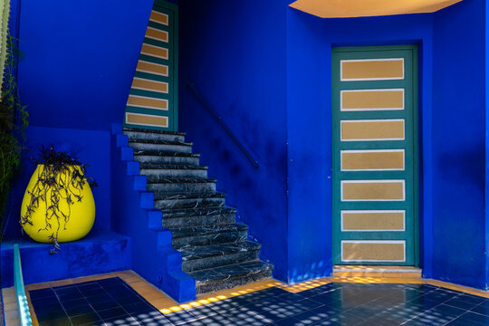 Exploring vibrant colors of Majorelle Garden with blue walls and a yellow vase in Marrakech, Morocco