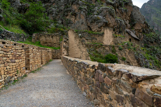 Explore Inca ruins and stone pathways at Ollantaytambo archaeological site in Peru surrounded by mountains and greenery