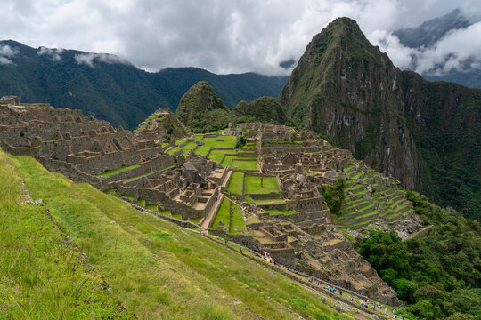Explore the Inca ruins of Machu Picchu on a cloudy day in Peru with stunning mountain views